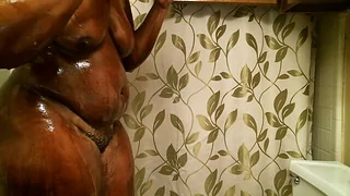 Busty black mom enjoys a steamy shower scene