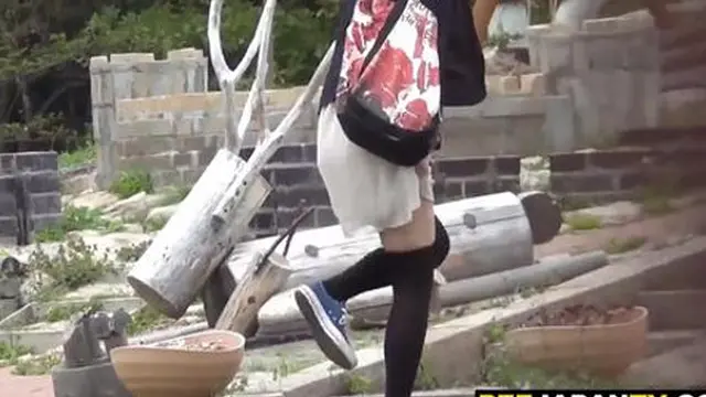 Teen Asian girl peeing outside in the open